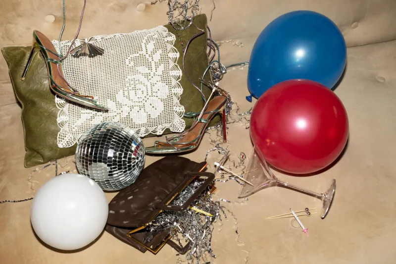 Na tleh dva balonma blazina, ženski salonarji, disko krogla, martini klozarec, torbica